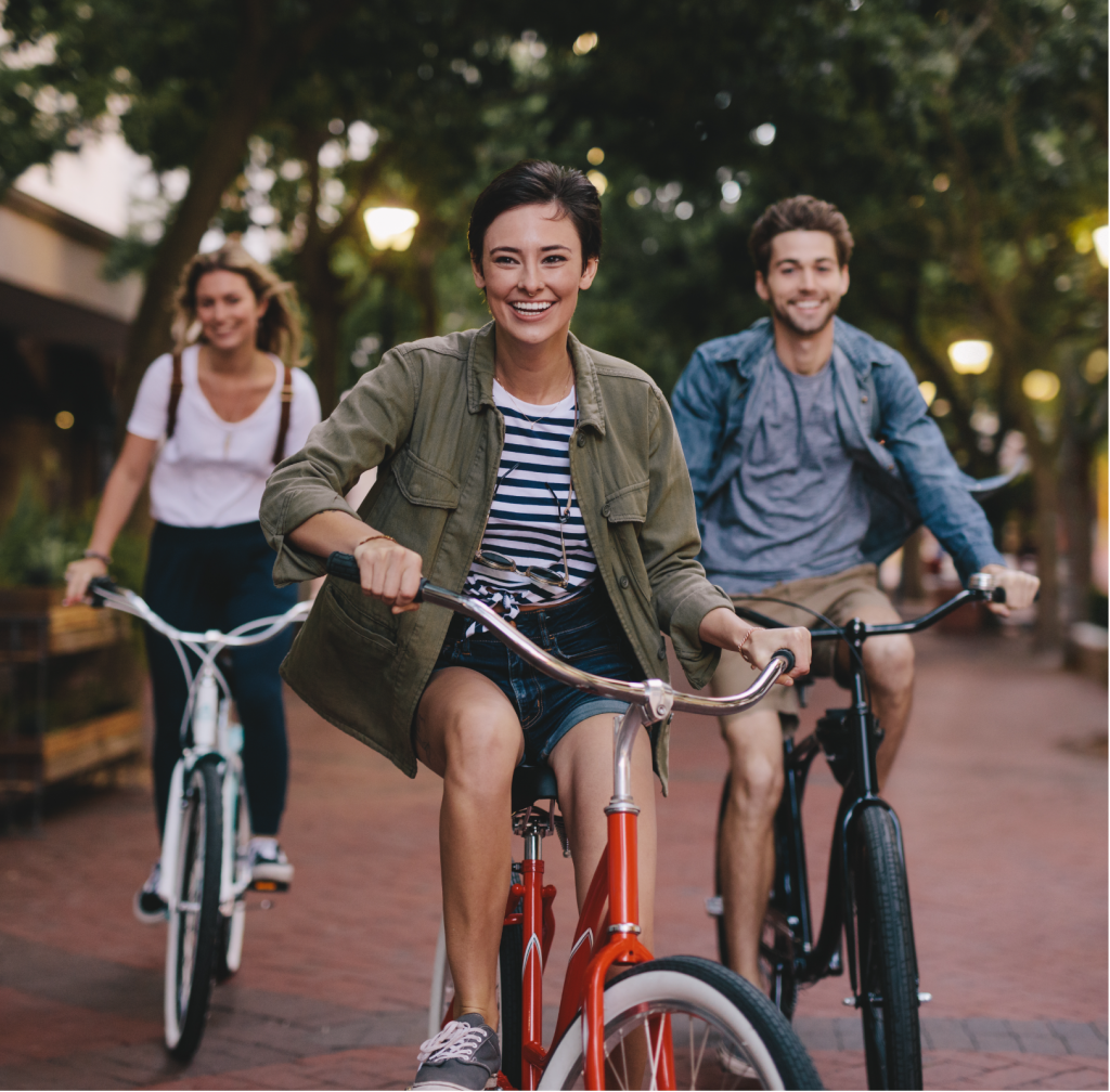 young people riding a bike in a neighborhood