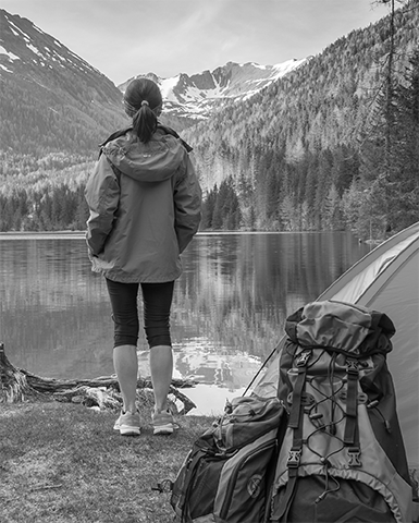 Woman camping in woods by the lake