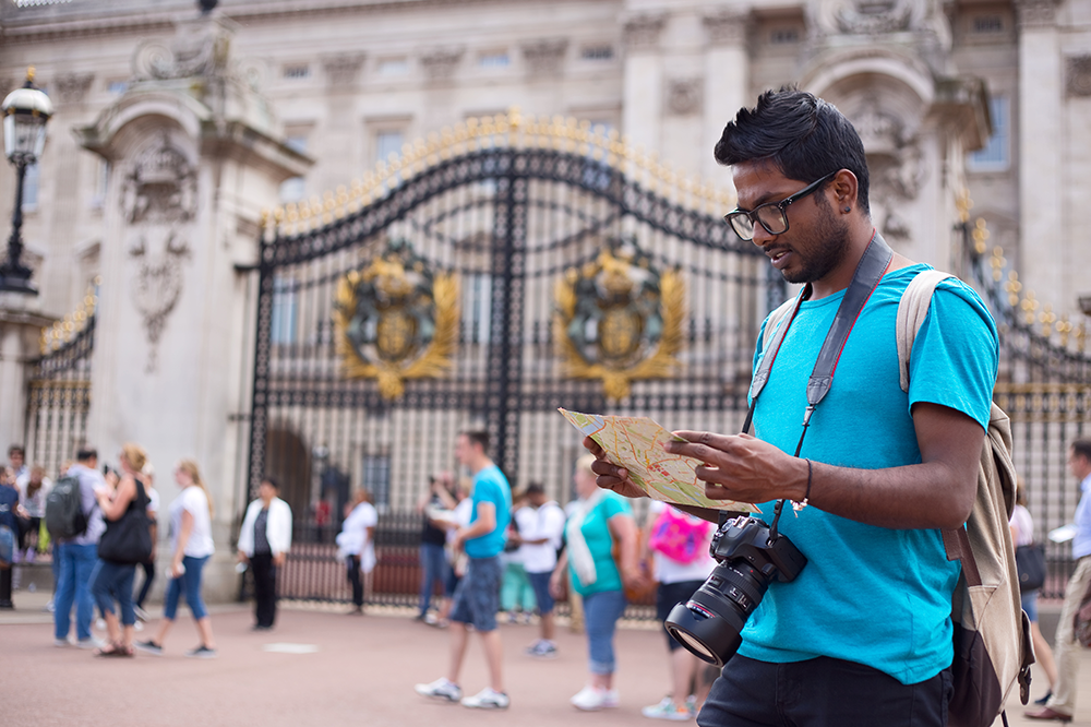 Man looking at map in front of Buckingham Palace